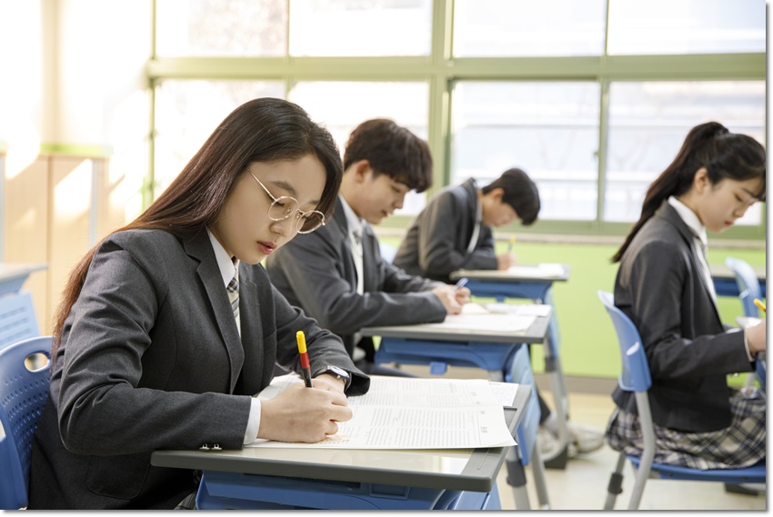 영어 서술형 답안 점검 순서 — 교실에서 교재를 읽는 학생들